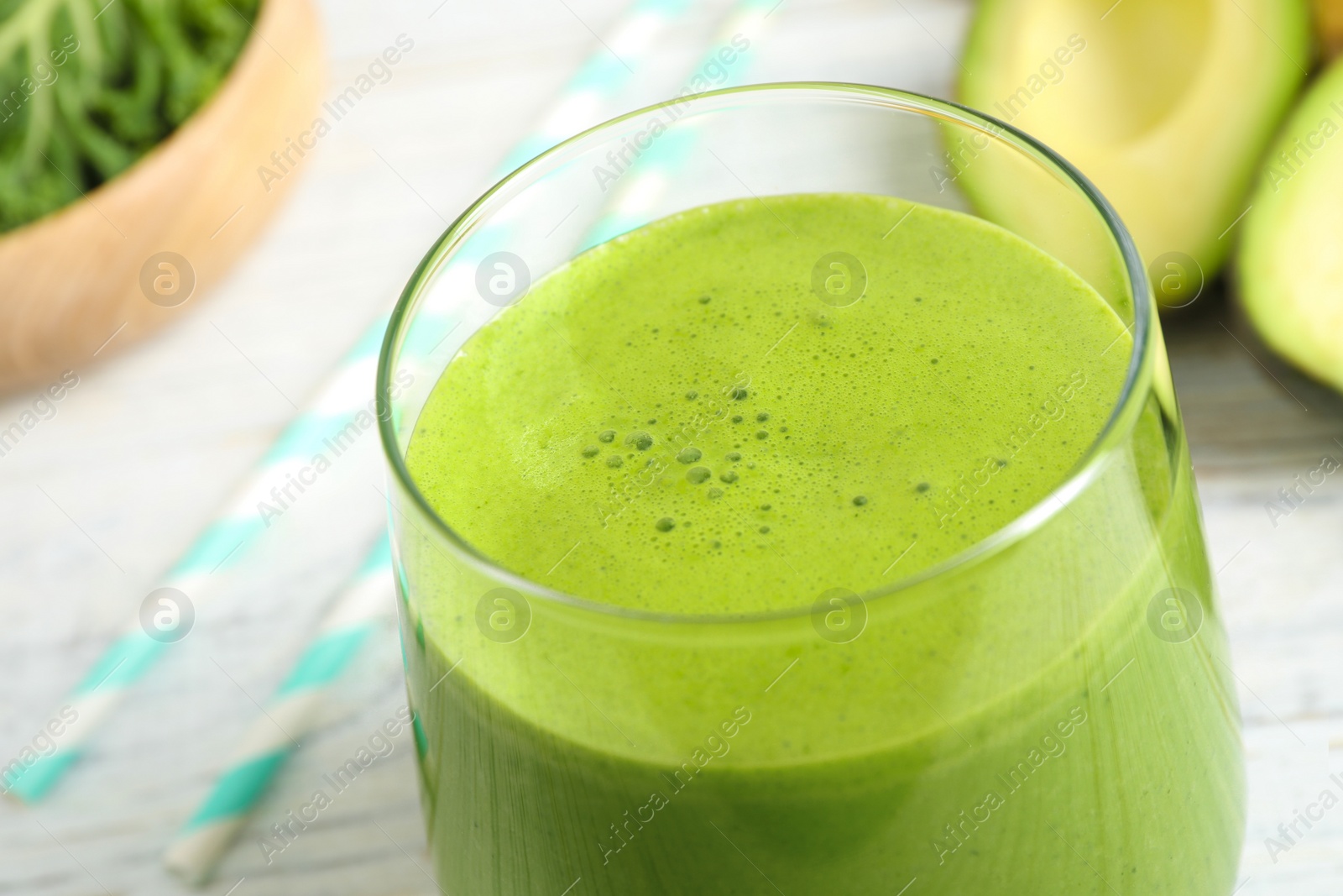 Photo of Tasty fresh kale smoothie on white wooden table, closeup