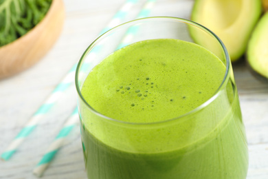 Photo of Tasty fresh kale smoothie on white wooden table, closeup