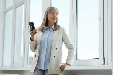 Senior woman using mobile phone at home