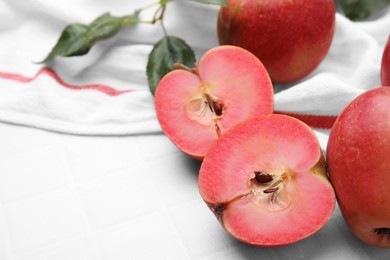 Tasty apples with red pulp on white tiled table, closeup. Space for text
