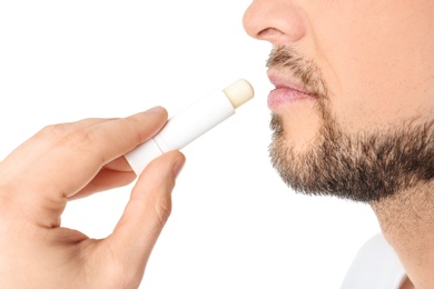 Man applying hygienic lip balm, on white background