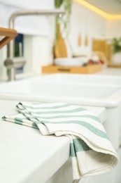 Photo of Clean towel near white sink in kitchen