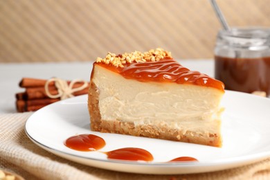 Tasty cheesecake with caramel and nuts served on table, closeup