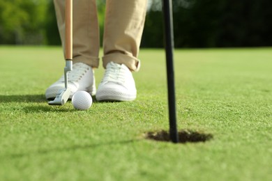 Person playing golf on green course, closeup