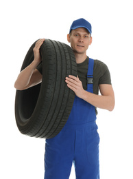 Portrait of professional auto mechanic with tire on white background