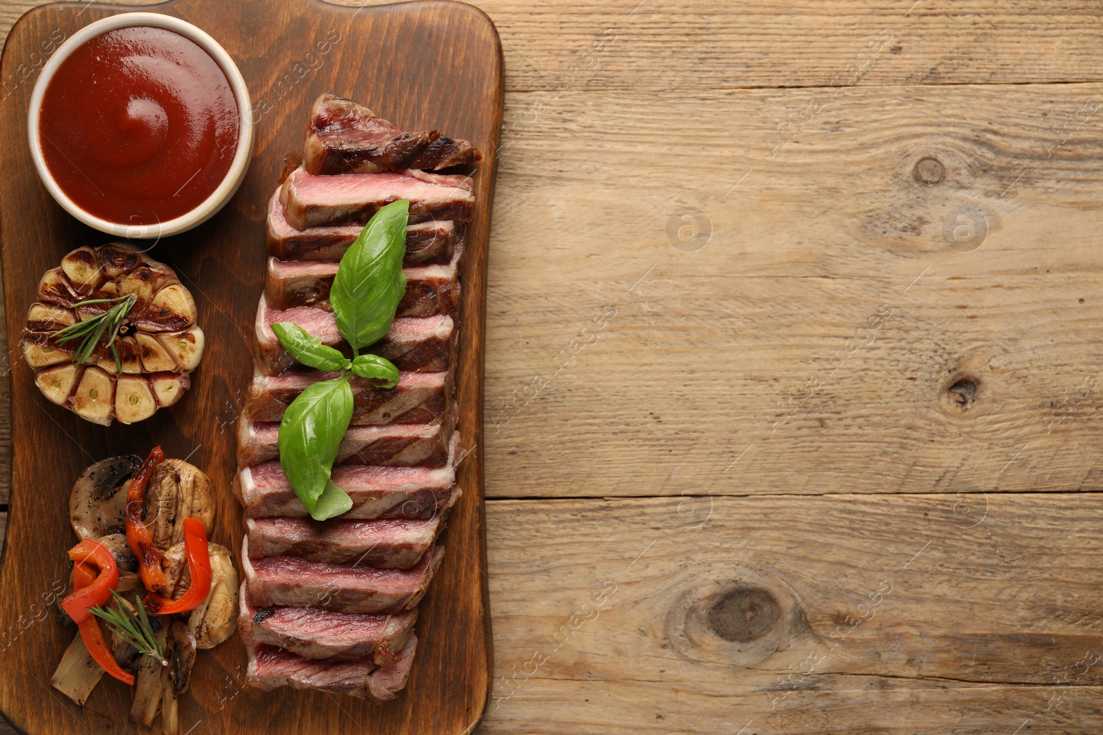 Photo of Delicious grilled beef steak with spices and tomato sauce on wooden table, top view. Space for text