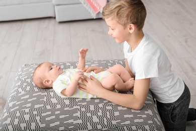Photo of Cute boy playing with little baby at home