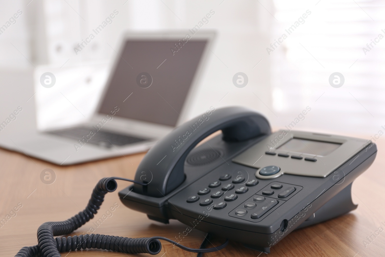 Photo of Stationary phone on wooden table indoors, space for text. Hotline service