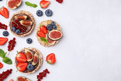 Photo of Flat lay composition with tasty crispbreads and berries on light table. Space for text