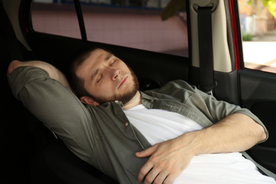 Tired man sleeping in his modern car