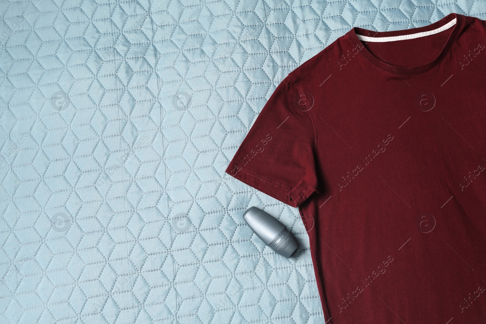 Photo of Male roll-on deodorant and t-shirt on light green plaid, flat lay. Space for text