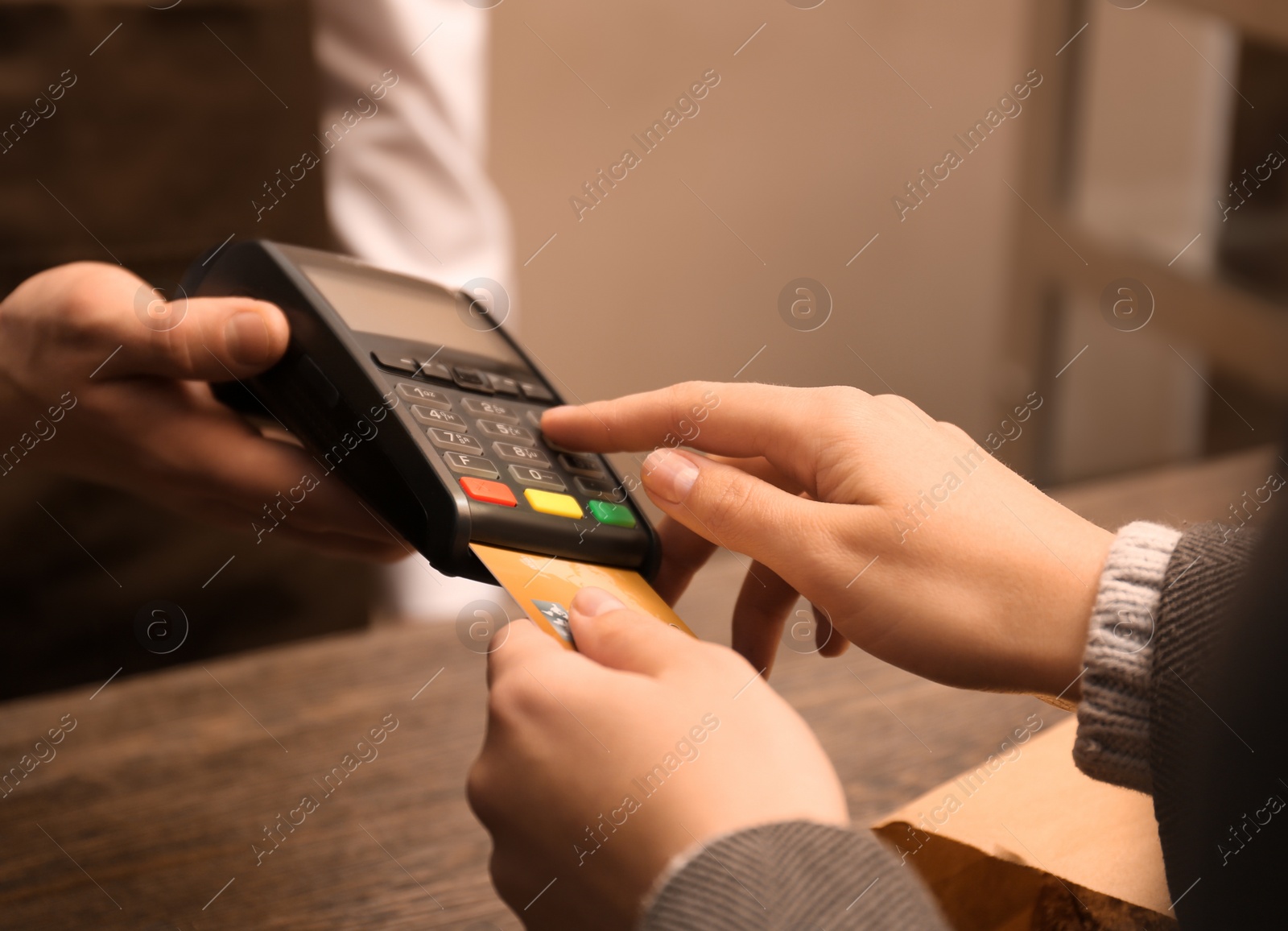 Photo of Woman with credit card using payment terminal at shop, closeup