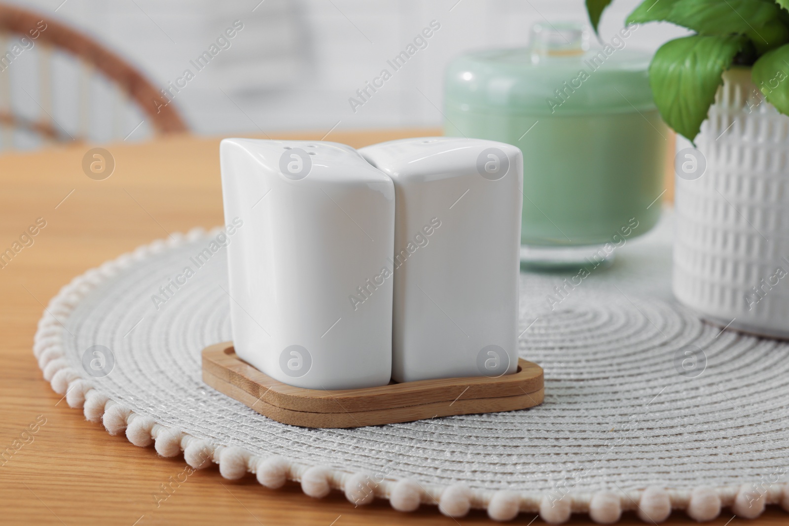 Photo of Ceramic salt and pepper shakers on wooden table