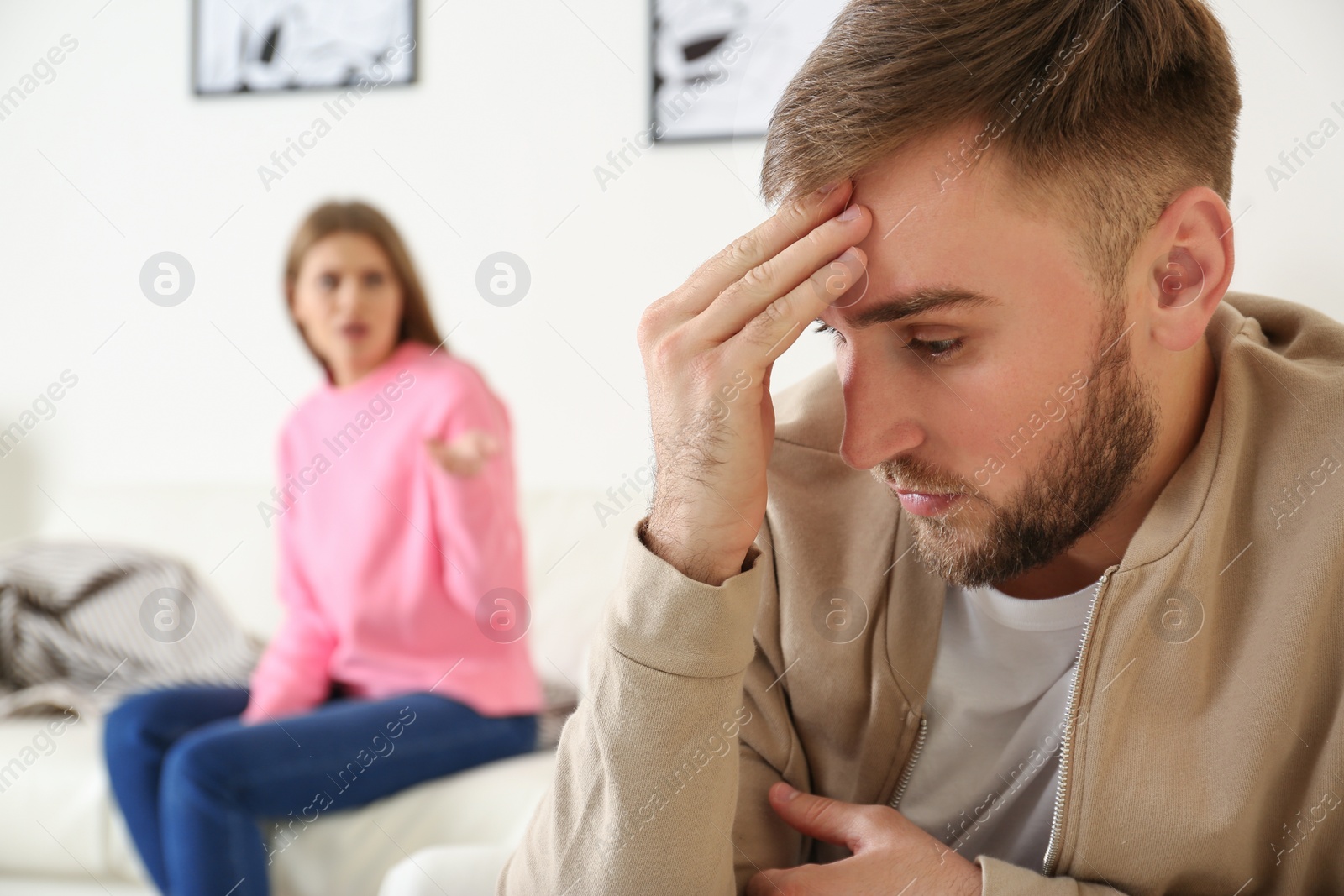 Photo of Young couple ignoring each other after argument in living room. Relationship problems