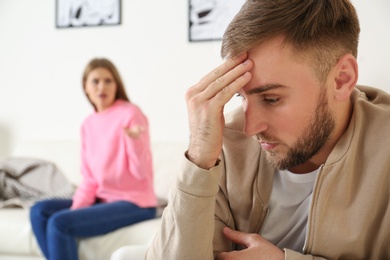 Photo of Young couple ignoring each other after argument in living room. Relationship problems