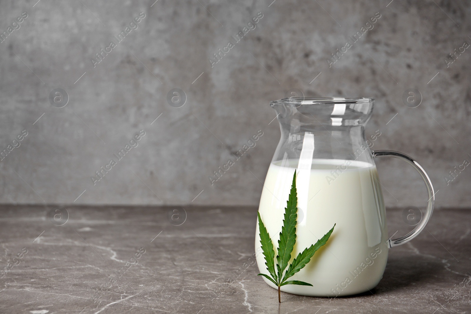 Photo of Pitcher of hemp milk on grey table