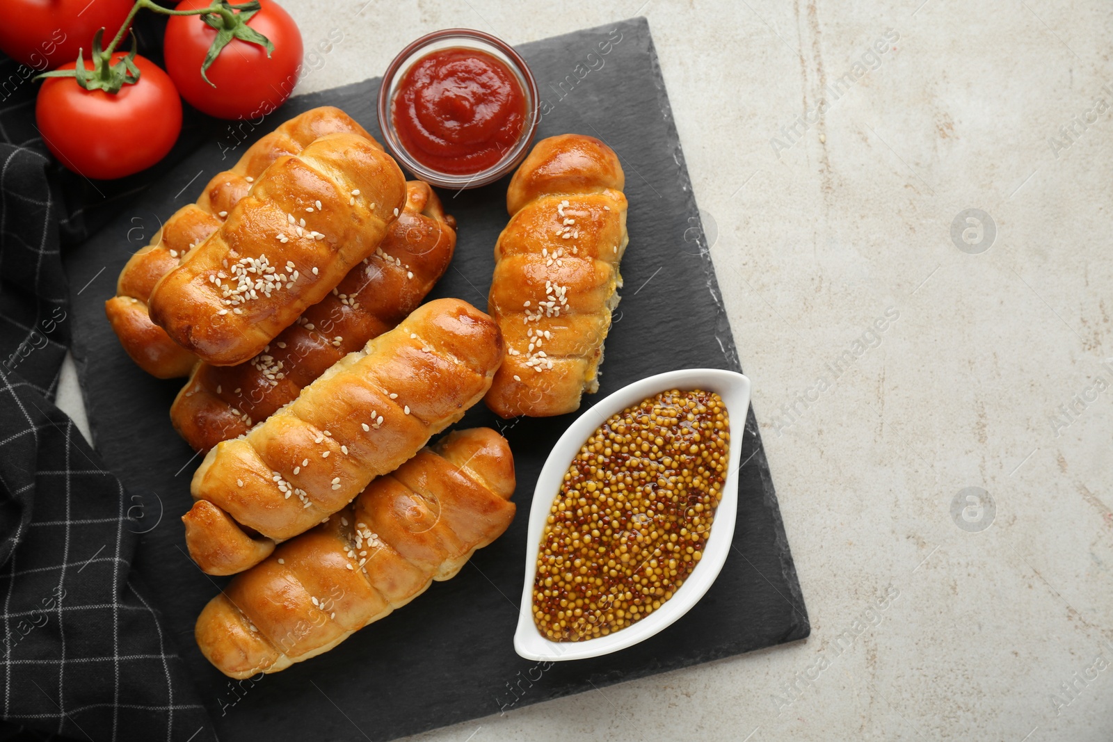 Photo of Delicious sausage rolls and ingredients on beige table, flat lay. Space for text