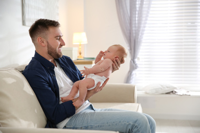 Photo of Father with his newborn son at home