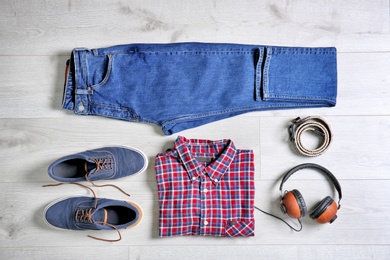 Set of trendy male clothes and accessories on wooden background, flat lay