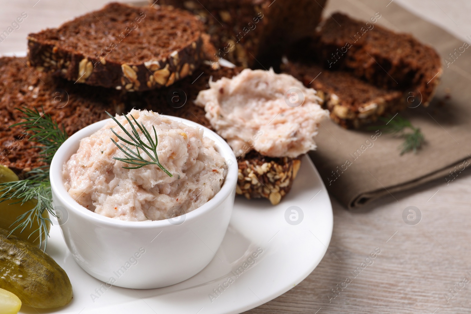 Photo of Delicious lard spread, bread and pickles on wooden table