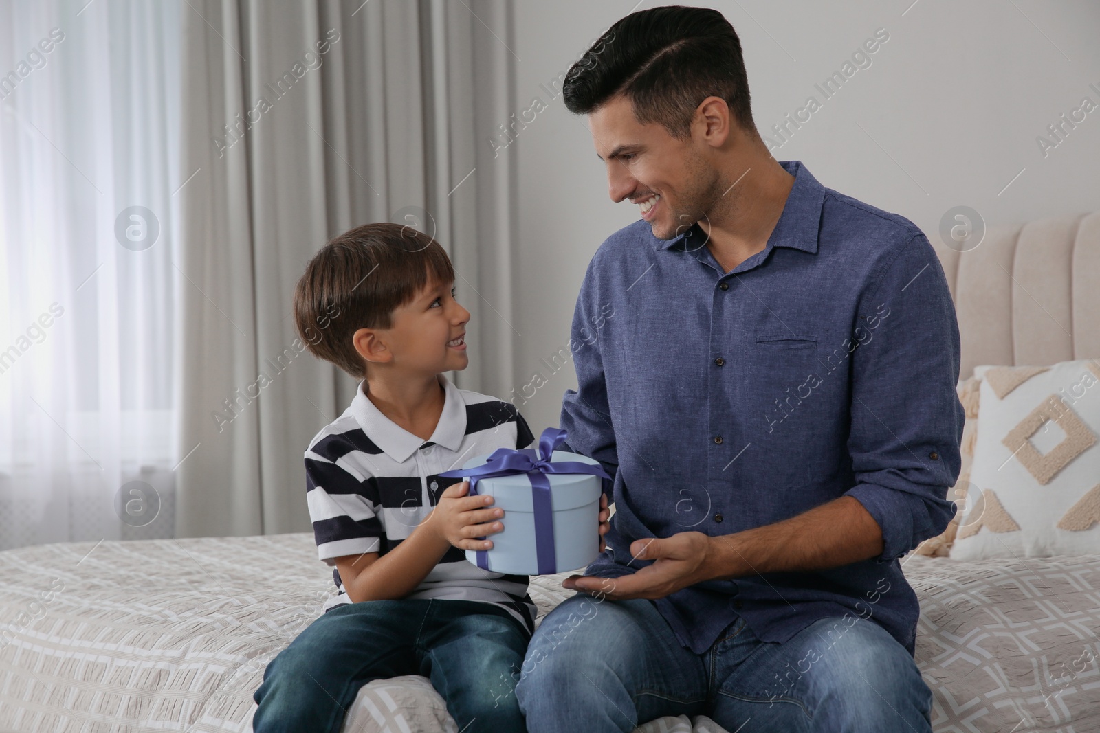 Photo of Man receiving gift for Father's Day from his son at home