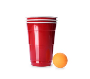 Photo of Red plastic cups and ball for beer pong on white background