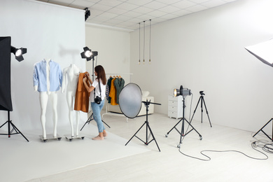 Woman putting clothes on ghost mannequins in professional photo studio