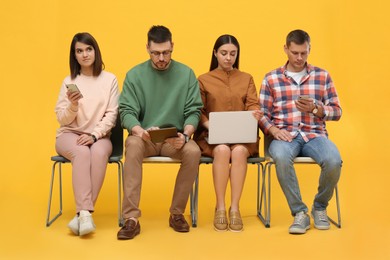 Photo of People waiting for job interview on yellow background