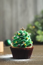 Photo of Christmas tree shaped cupcake on wooden table