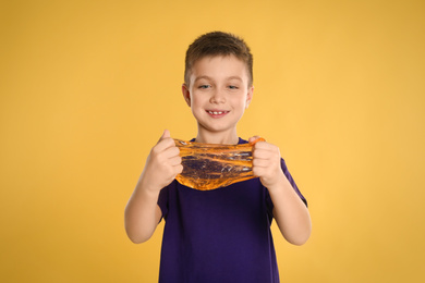 Photo of Little boy with slime on yellow background