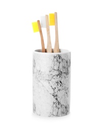 Photo of Bamboo toothbrushes in holder on white background. Dental care