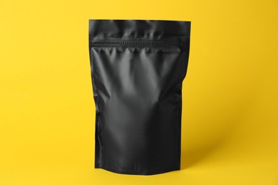 Photo of One blank foil package on yellow background