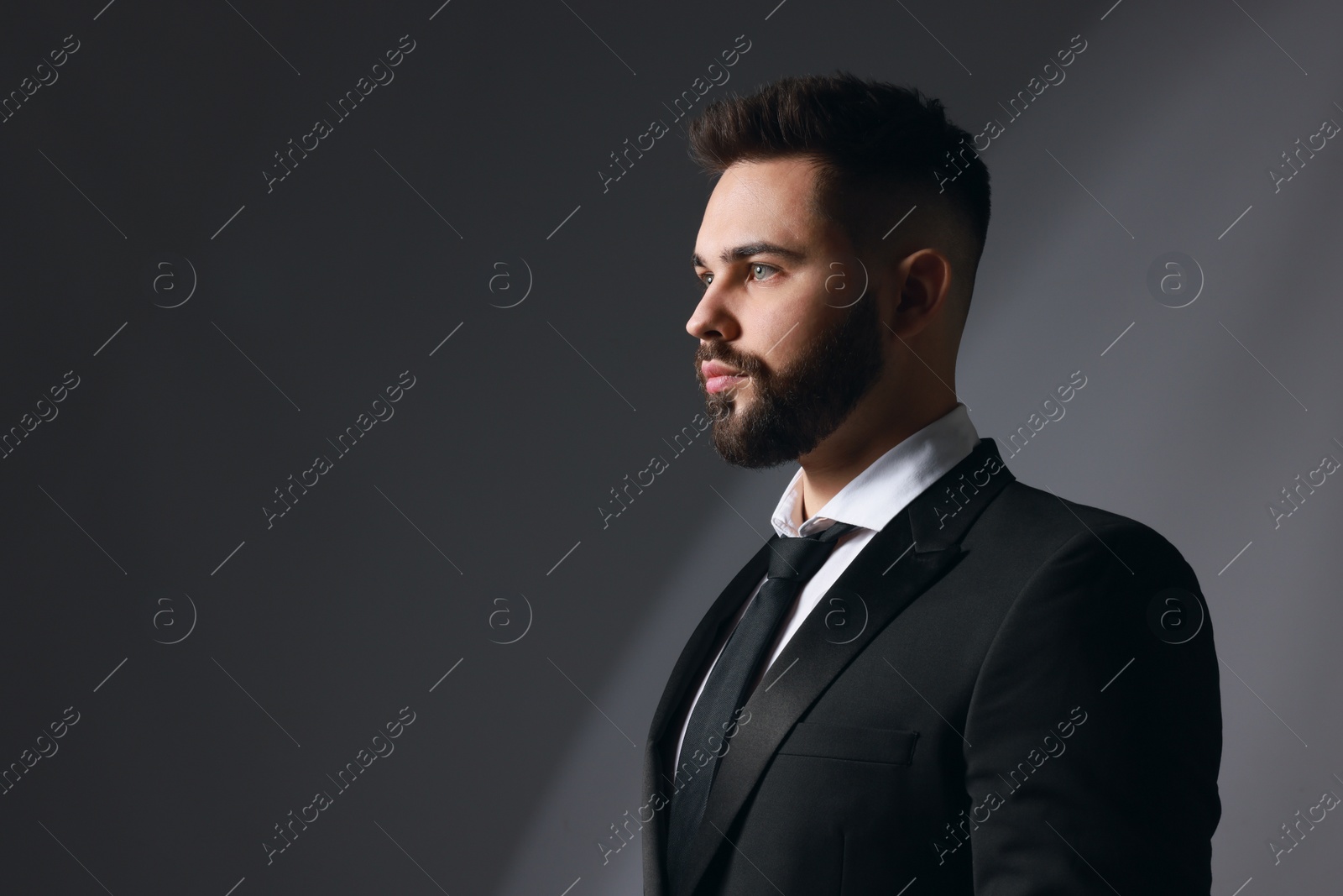 Photo of Handsome bearded man in stylish suit on grey background. Space for text