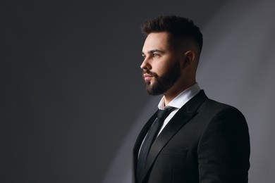 Photo of Handsome bearded man in stylish suit on grey background. Space for text