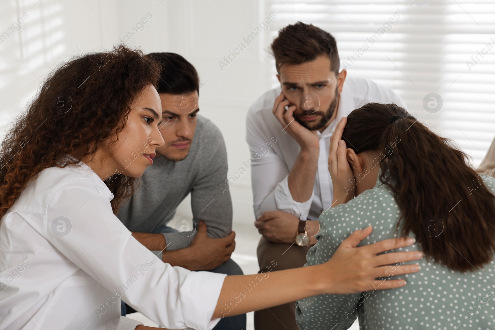 Photo of Psychotherapist working with patient at group session indoors