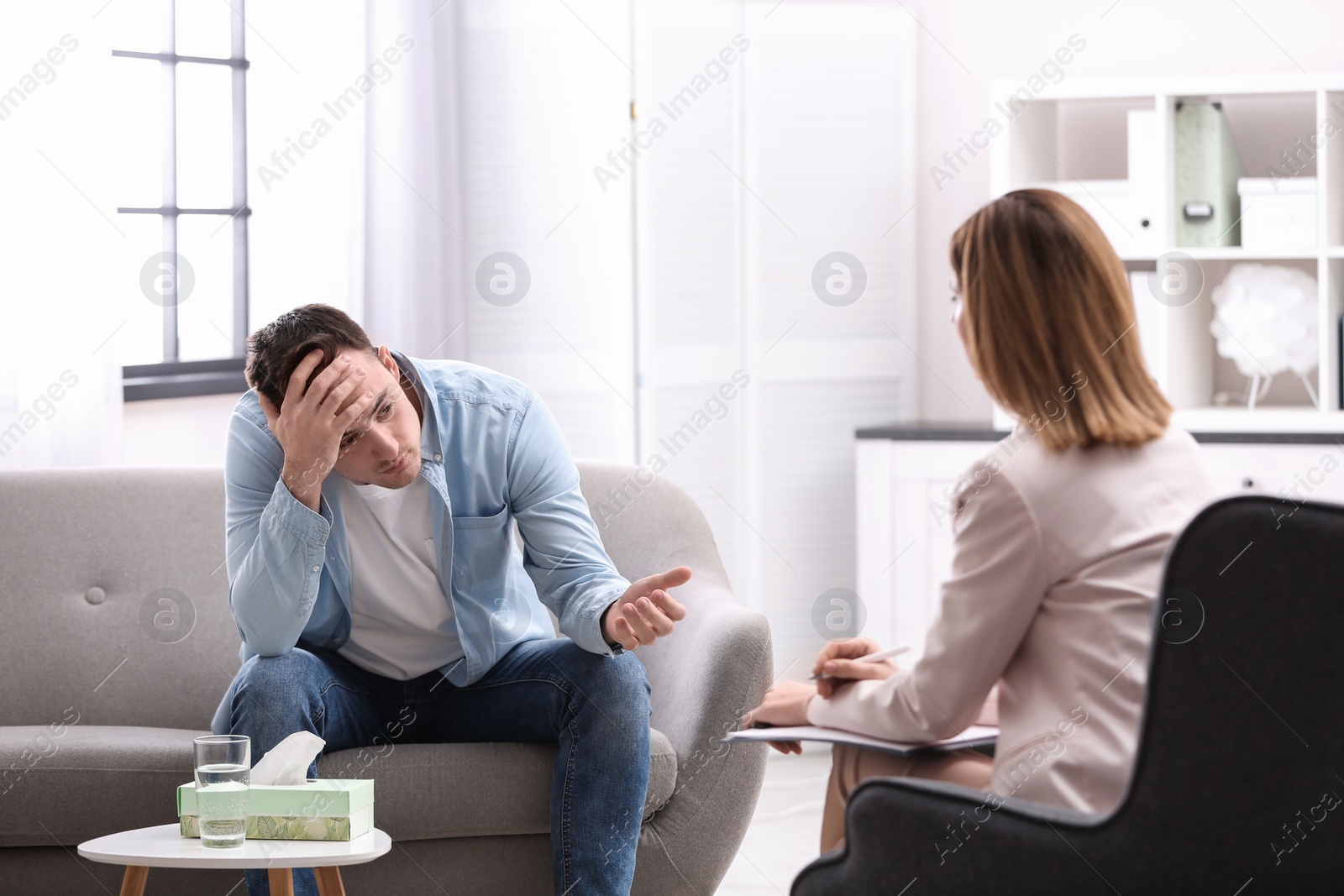 Photo of Psychotherapist working with young man in office