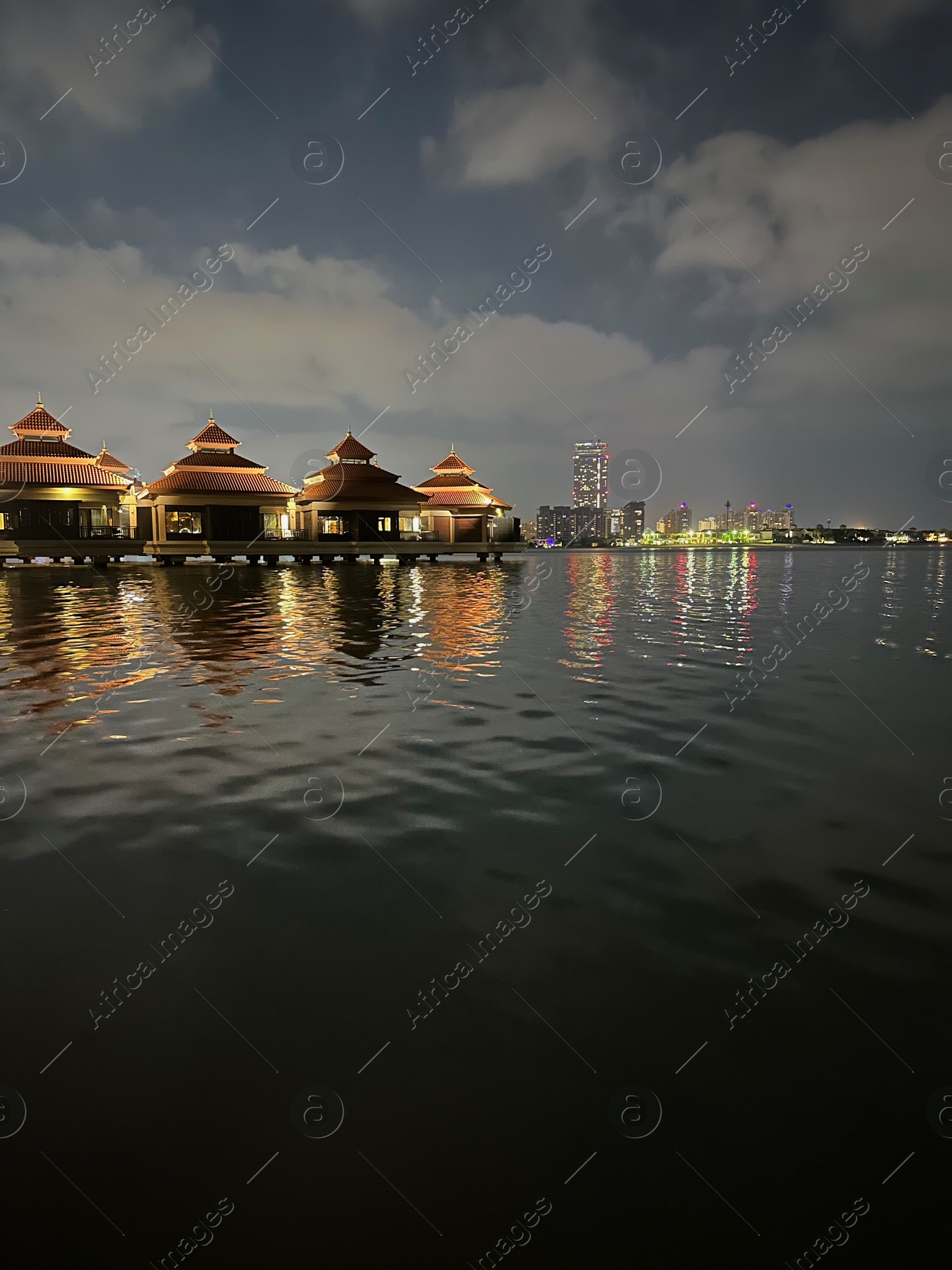 Photo of Beautiful view of night cityscape with sea and illuminated buildings