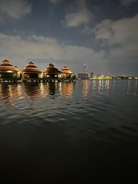 Photo of Beautiful view of night cityscape with sea and illuminated buildings