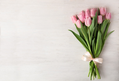 Photo of Beautiful pink spring tulips on white wooden background, top view. Space for text