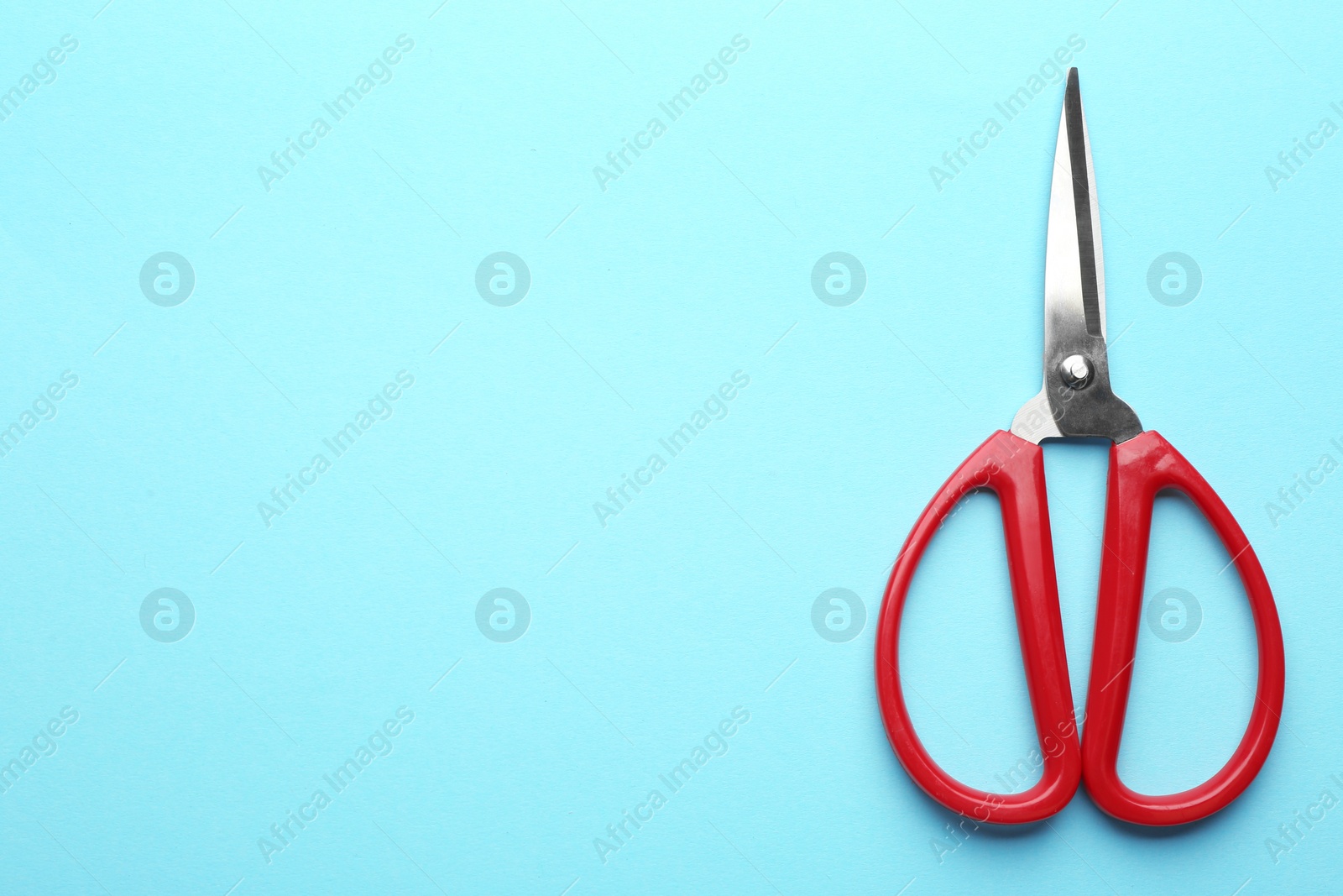 Photo of Pair of sharp scissors on color background, top view. Space for text