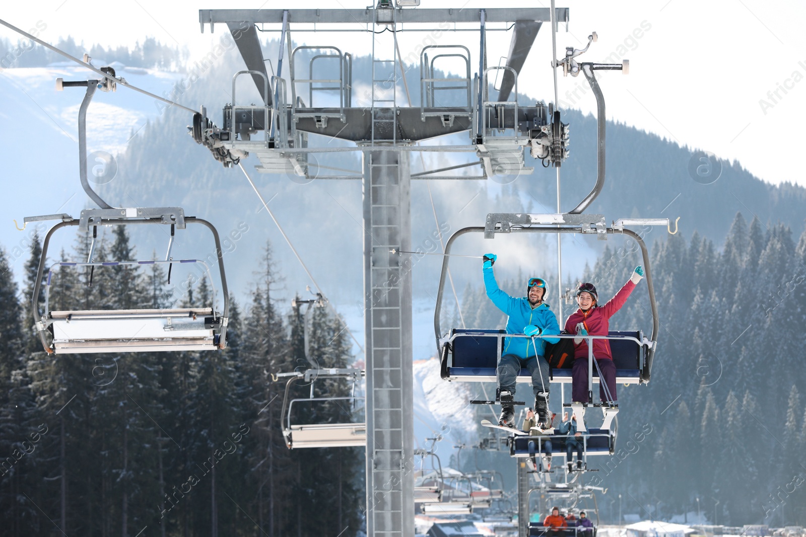 Photo of People using chairlift at mountain ski resort. Winter vacation