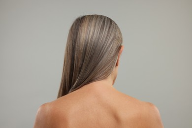 Photo of Mature woman with healthy skin on grey background, back view