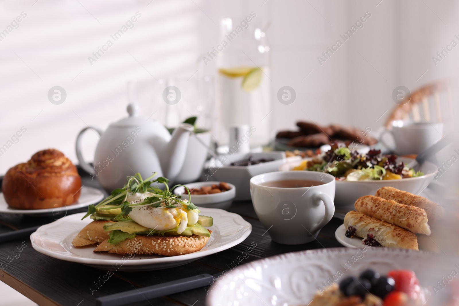 Photo of Delicious sandwiches with eggs and avocado served on buffet table for brunch