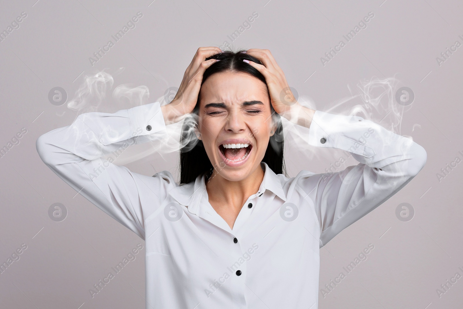 Image of Stressed and upset young woman on light grey background