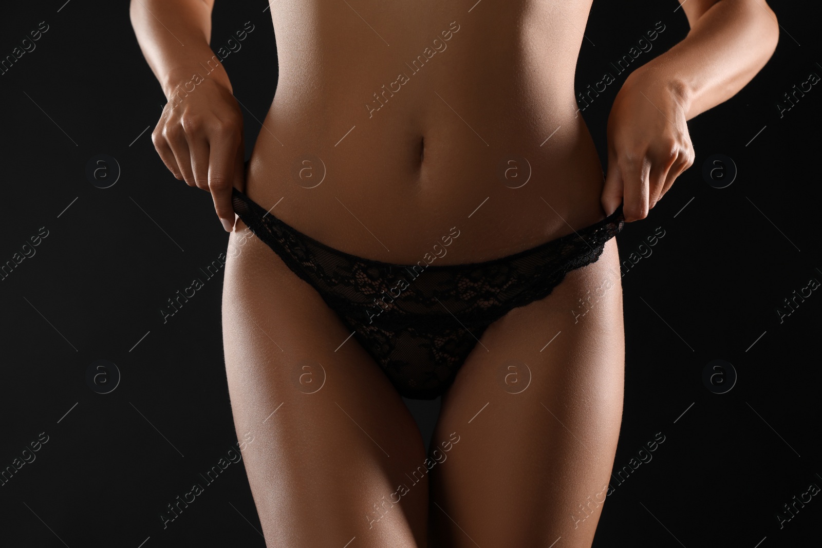 Photo of Woman in sexy panties on black background, closeup