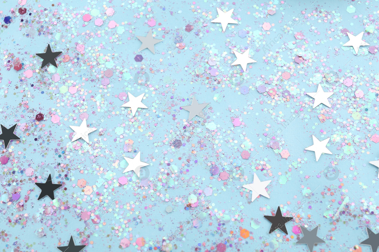 Photo of Shiny glitter on light blue background, flat lay