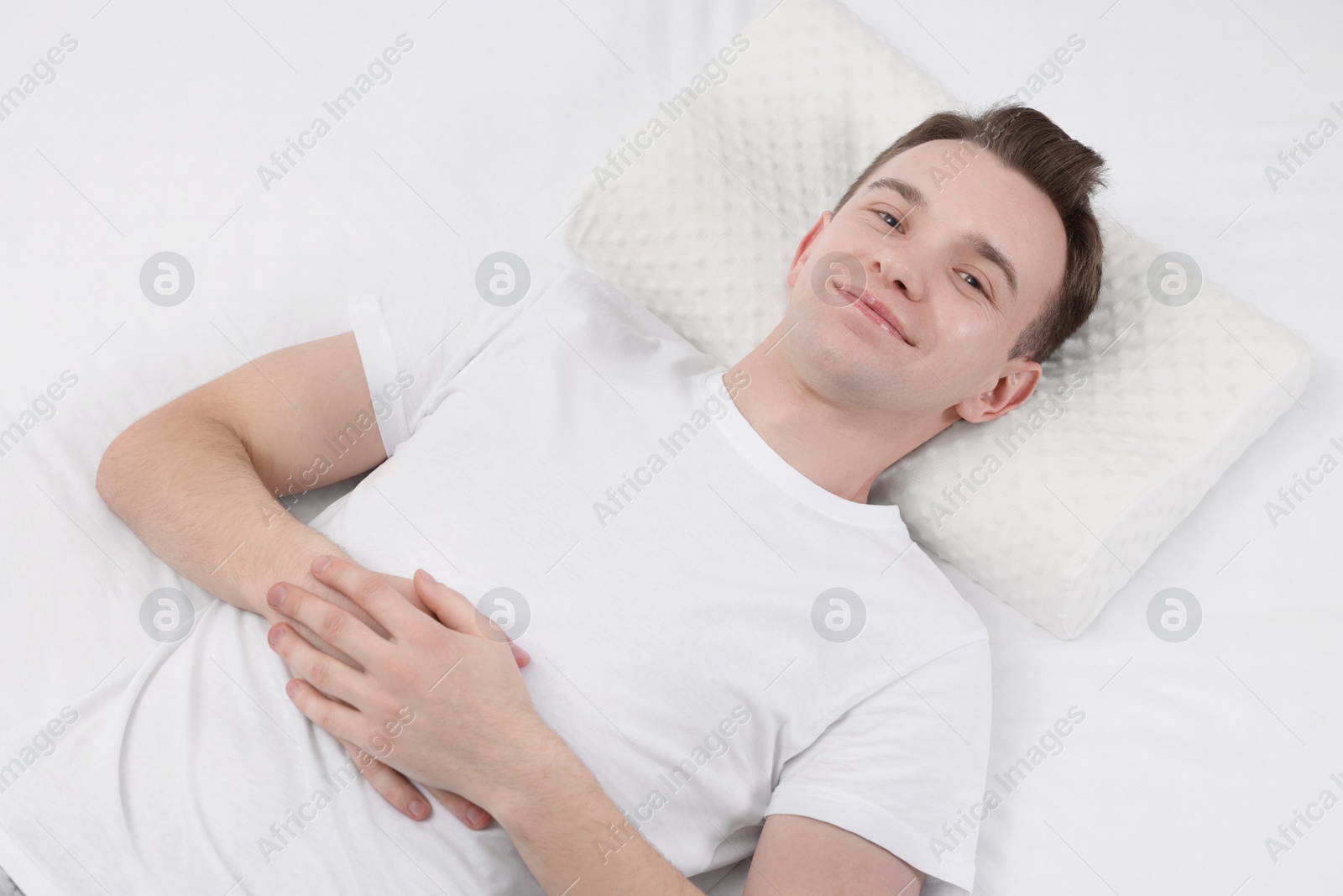 Photo of Man lying on orthopedic pillow in bed