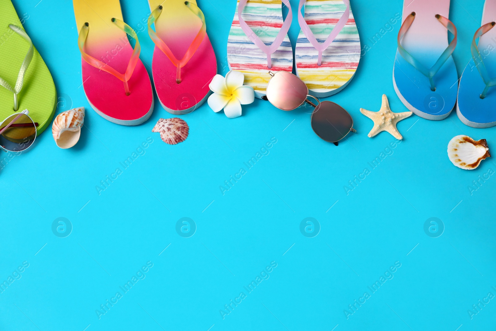 Photo of Flat lay composition with different flip flops on blue background, space for text. Summer beach accessories