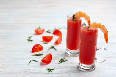 Photo of Shrimp cocktail with tomato sauce on white wooden table