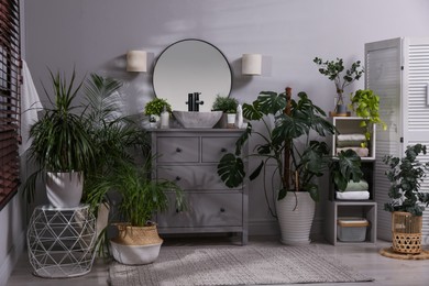 Photo of Stylish bathroom interior with modern furniture and beautiful green houseplants